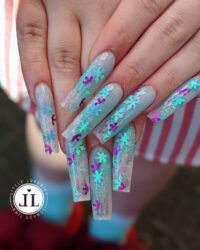 Nail art design from Little Luxuries Nail Lounge featuring glittery snowflakes