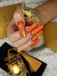 Red nail art manicure with gold detail design from Little Luxuries Nail Lounge