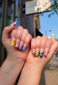 Nail art design from Little Luxuries Nail Lounge featuring colorful styled tips